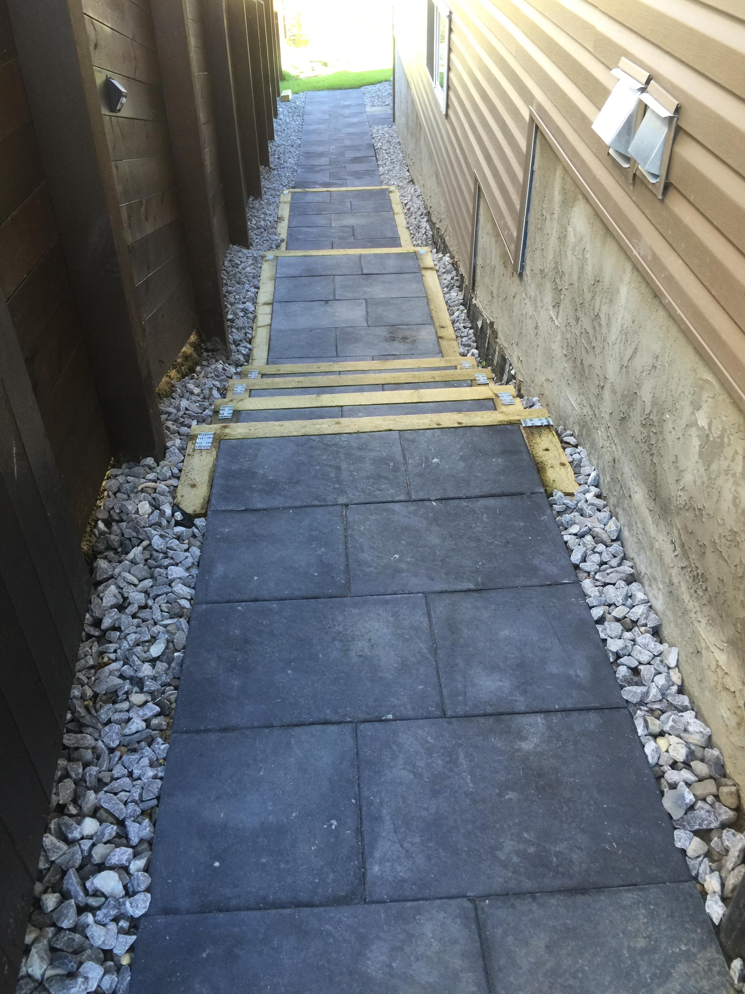 Narrow side yard pathway with dark slate tiles and timber step risers